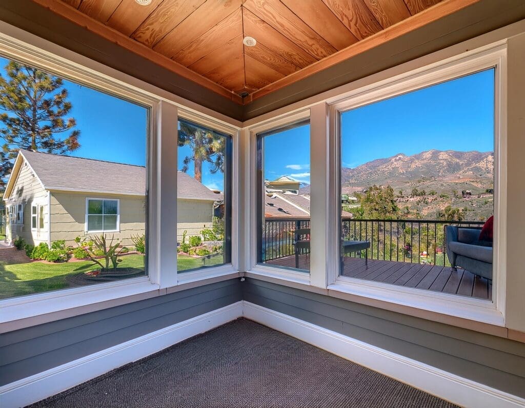 A bay window installation in a California home, providing a wide view of the backyard garden. J Kidd Construction